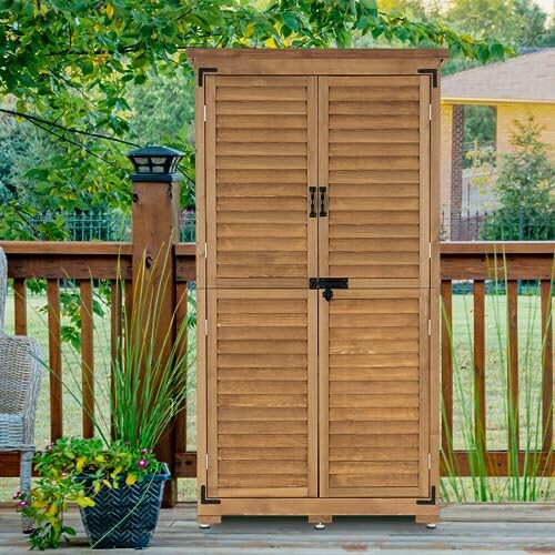 Wooden storage shed on a patio surrounded by plants.