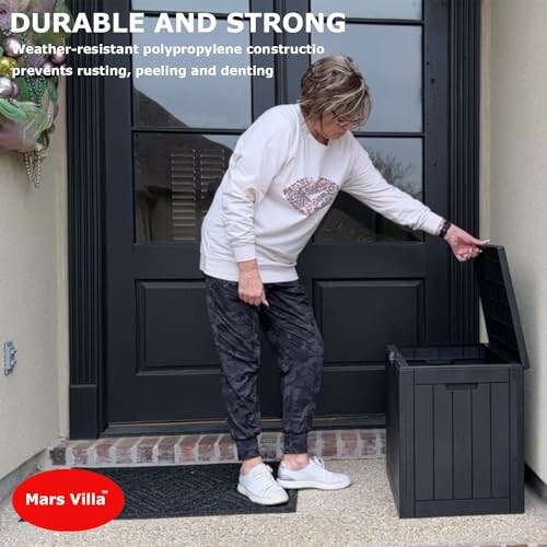 Person opening a black outdoor storage box on a porch.